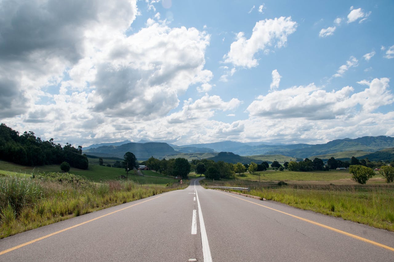 Expansive highway view with lush landscape under a vibrant sky in South Africa.